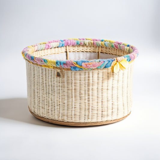 A large, woven storage bin with a vibrant floral pattern featuring pastel pink, yellow, and blue blooms on a crisp white background, surrounded by neatly folded linens and a few stray petals.